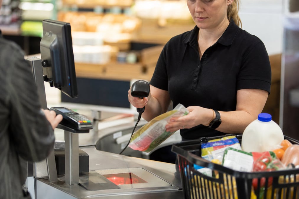 Restaurant staff using a modern wireless POS terminal for transactions.