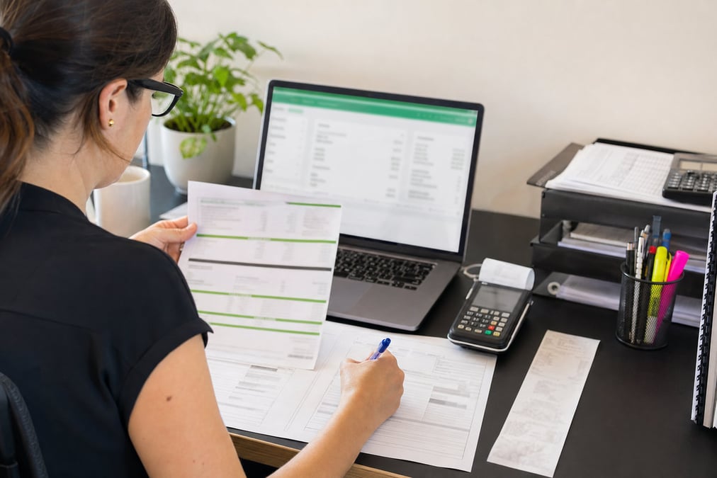 Two professionals collaborating on financial documents in a modern office setting.
