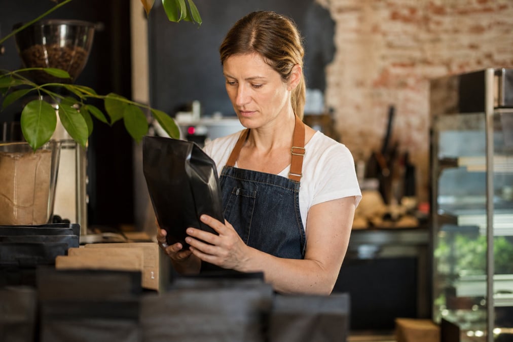 A customer using a touch screen system at a cafe counter for modern payment processing.