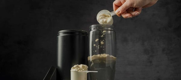 Protein powder being scooped into a shaker — Australian Sports Nutrition case study